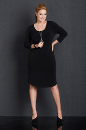 Model Mercy wearing size 14 of the Belle Base Layer Dress in colour Black (Black), from the front, showing the whole outfit