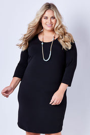 Model Sophie wearing size 22 of the Belle Base Layer Dress in colour Black (Black), from the front, cropped image