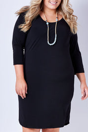 Model Sophie wearing size 22 of the Belle Base Layer Dress in colour Black (Black), from the front, cropped image