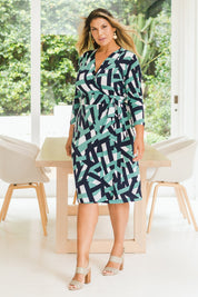 Model Palatina wearing size 16 of the Belle Abstract Wrap Dress in colour Abstract (Green), from the front, showing the whole outfit