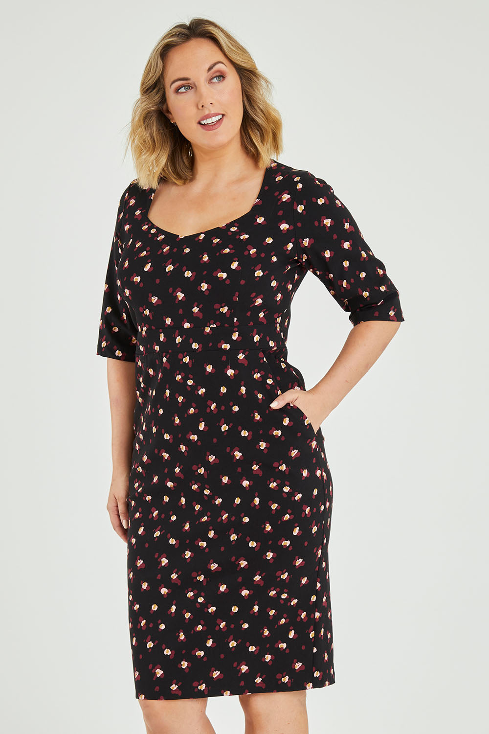 Model Jess wearing size 12 of the Belle Ditsy Floral Print Bengaline Dress in colour Ditsy (Black), from the front, cropped image