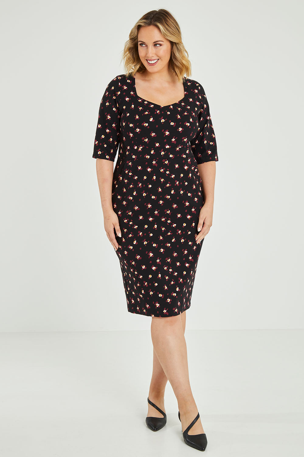 Model Jess wearing size 12 of the Belle Ditsy Floral Print Bengaline Dress in colour Ditsy (Black), from the front, showing the whole outfit