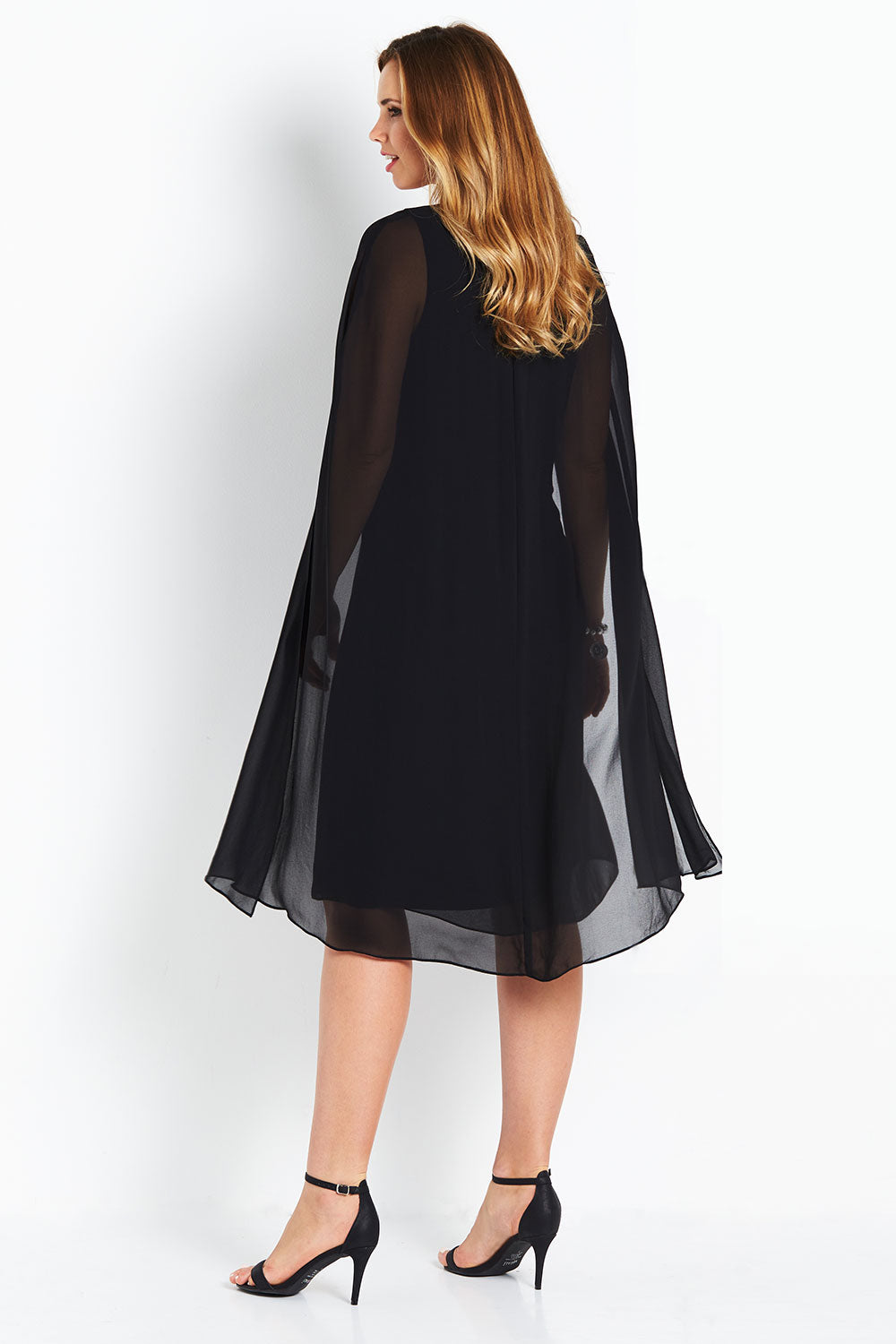 Model Bree wearing size 14 of the Belle Cape Dress in colour Black (Black), from the back
