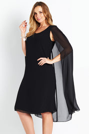 Model Bree wearing size 14 of the Belle Cape Dress in colour Black (Black), from the front, cropped image