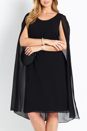 Model Bree wearing size 14 of the Belle Cape Dress in colour Black (Black), from the front, cropped image