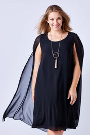 Model Kate wearing size 16 of the Belle Cape Dress in colour Black (Black), from the front, cropped image