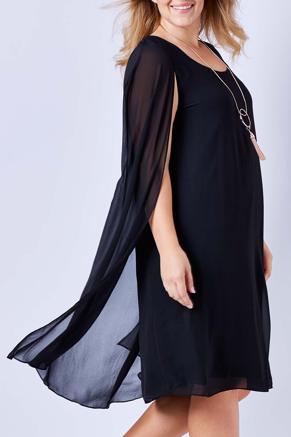 Model Kate wearing size 16 of the Belle Cape Dress in colour Black (Black), from the front, cropped image