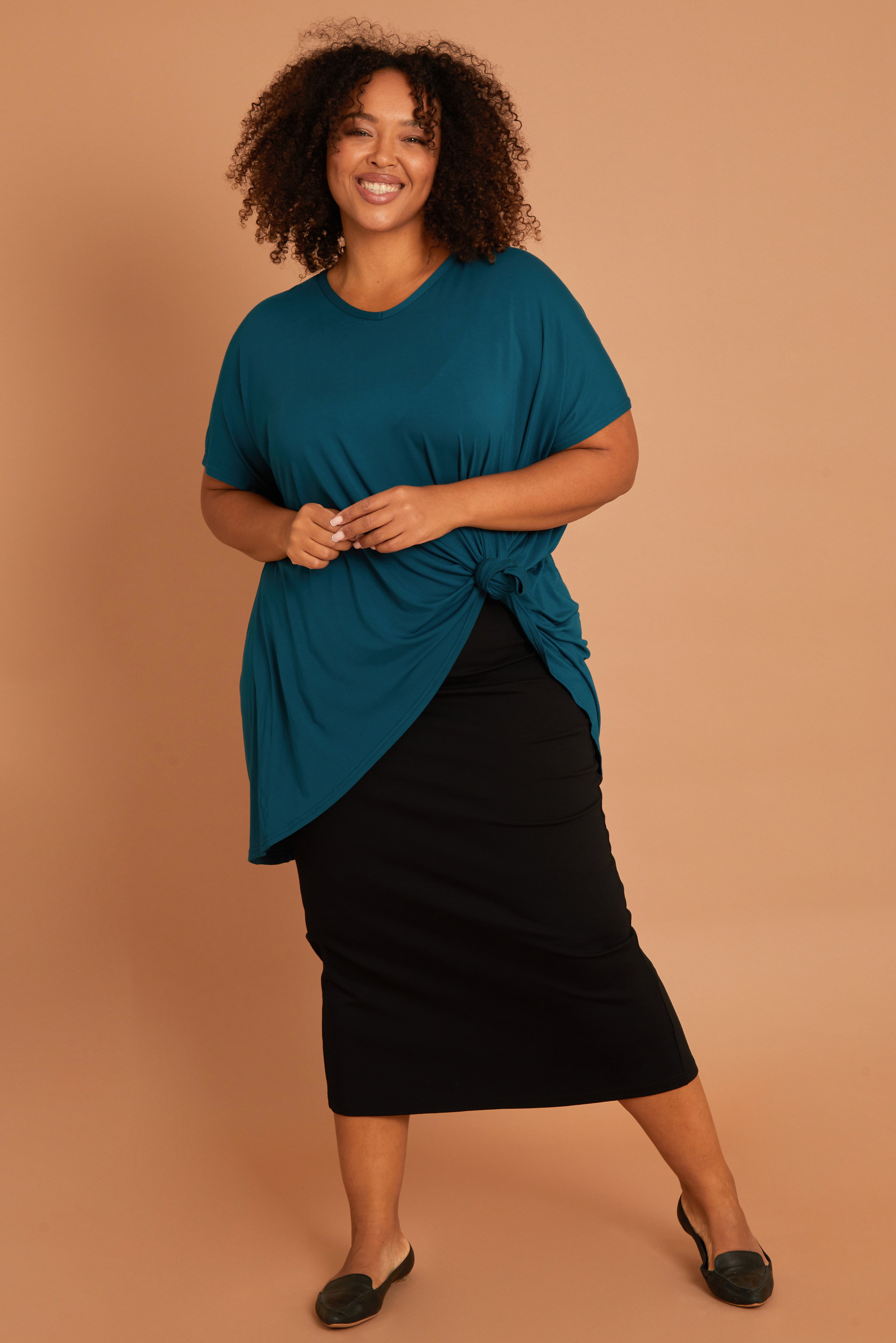 Model Alexis wearing size 16 of the Belle High Low Bamboo Tee in colour Petrol (Blue), from the front, showing the whole outfit