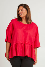 Model Monique wearing size 14 of the Belle Layered Cotton Linen Kaftan Top in colour Lipstick (Red), from the front, cropped image