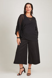 Model Poppy wearing size 16 of the Belle Chiffon Bubble Detail Top w/Cami in colour Black (Black), from the front, showing the whole outfit