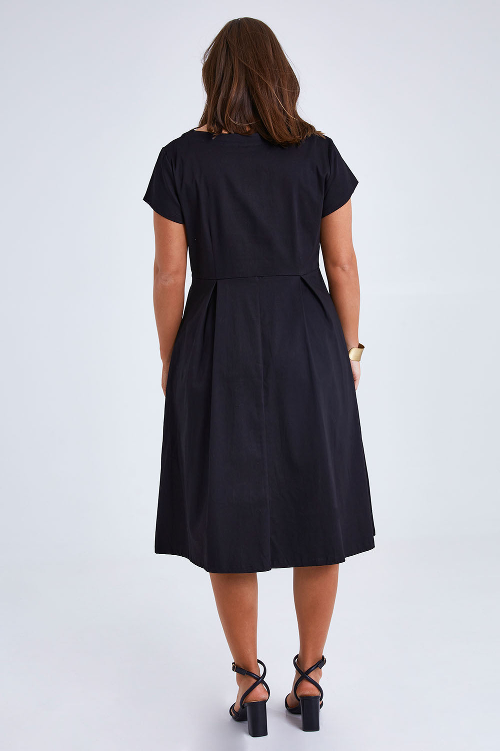 Model Monique wearing size 14 of the Belle Cotton Sateen Pleat Dress in colour Black (Black), from the back
