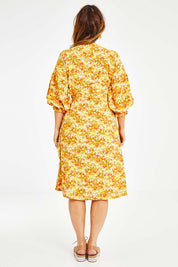 Model Laura wearing size 14 of the Meadow Walks Wrap Dress in colour Sunshine, from the back