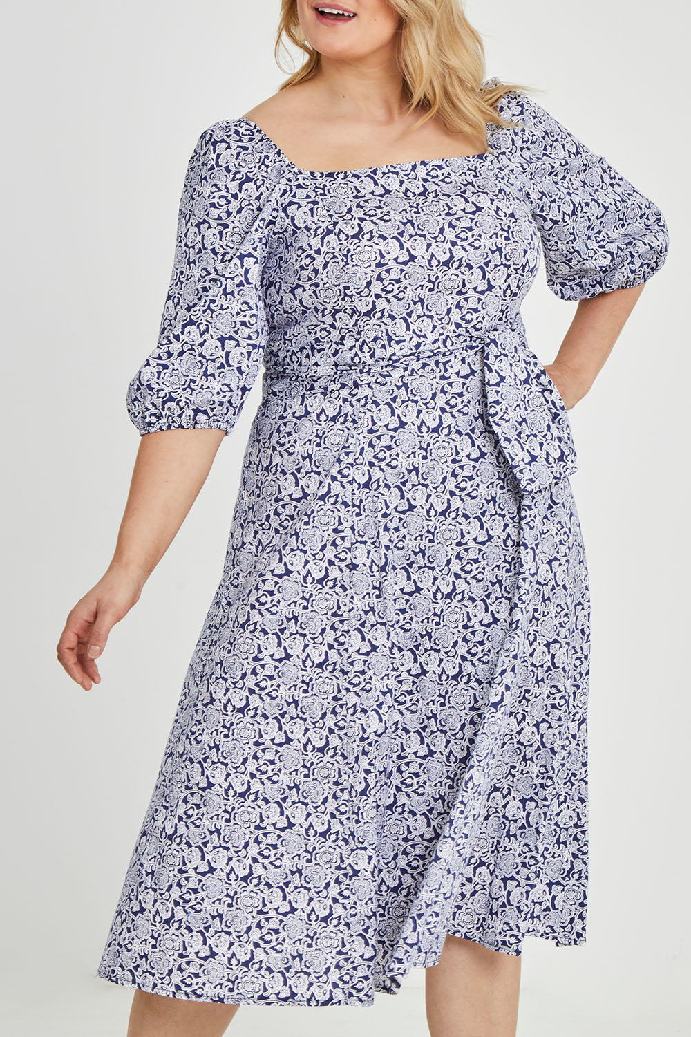 Model Keeara wearing size 16 of the Walking On Sunshine Dress in colour Navypais (Blue), from the front, cropped image
