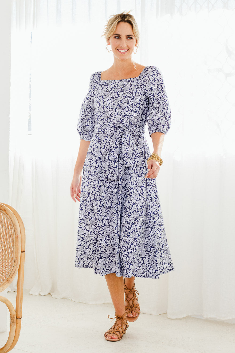 Model Tegan wearing size 10 of the Walking On Sunshine Dress in colour Navypais (Blue), from the front, showing the whole outfit