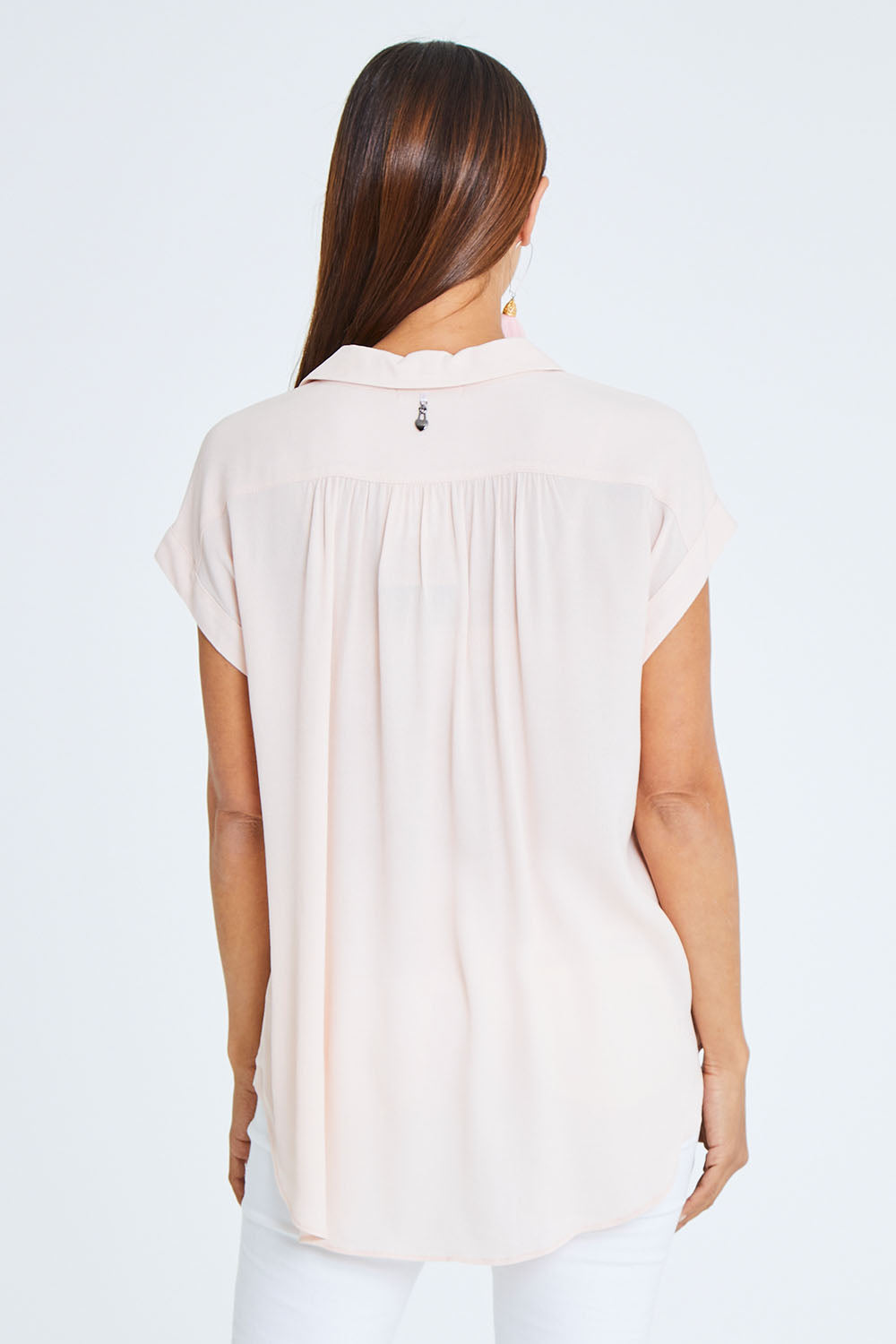 Model Cara wearing size 10 of the Go Your Own Way Button Blouse in colour Blush (Pink), from the back