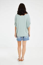Model Andrea wearing size 10 of the In My Arms Tee in colour Sage (Green), from the back