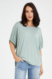 Model Andrea wearing size 10 of the In My Arms Tee in colour Sage (Green), from the front, cropped image