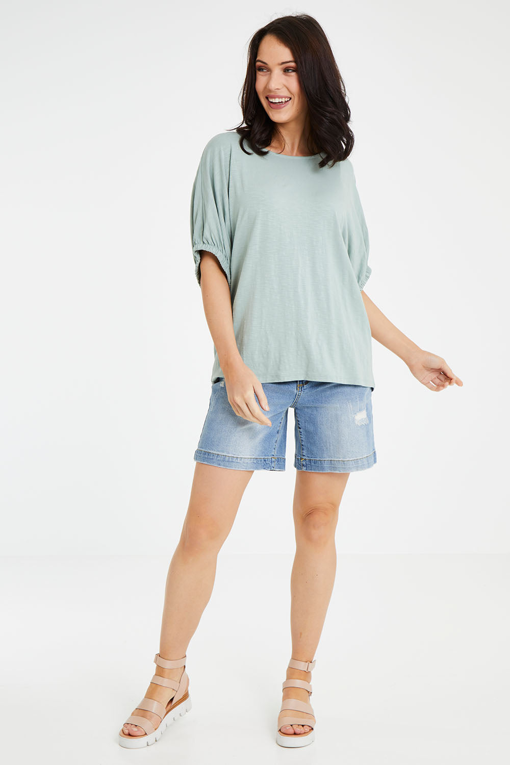 Model Andrea wearing size 10 of the In My Arms Tee in colour Sage (Green), from the front, showing the whole outfit