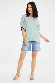 Model Andrea wearing size 10 of the In My Arms Tee in colour Sage (Green), from the front, showing the whole outfit