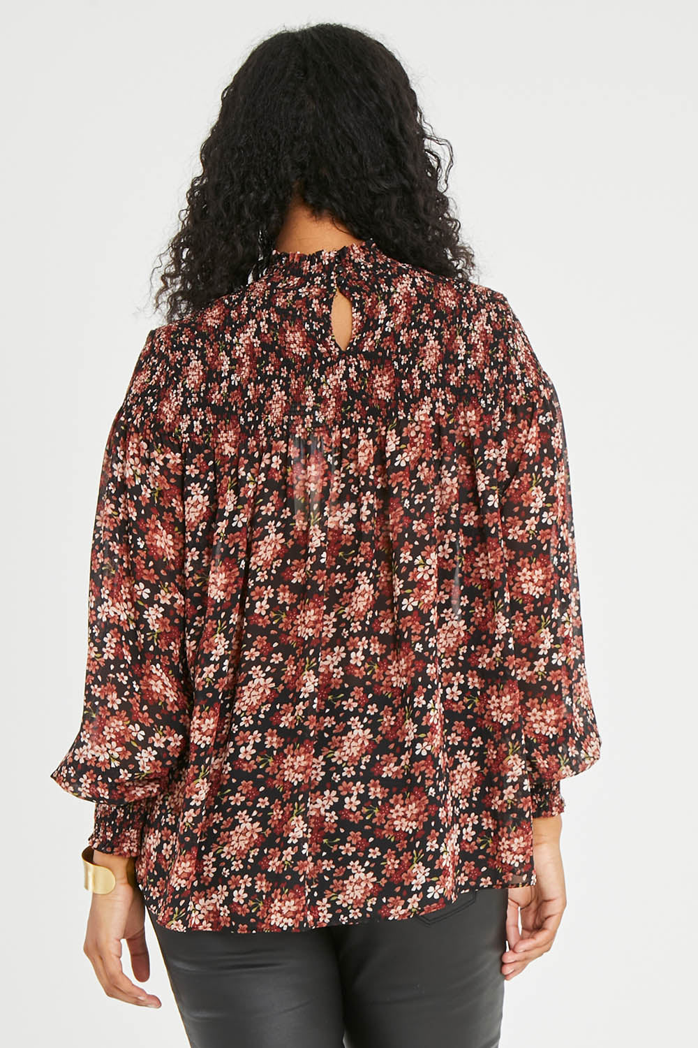 Model Noli wearing size 14 of the Romance In The Air Blouse in colour Blkrust (Black), from the back