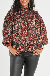 Model Noli wearing size 14 of the Romance In The Air Blouse in colour Blkrust (Black), from the front, cropped image