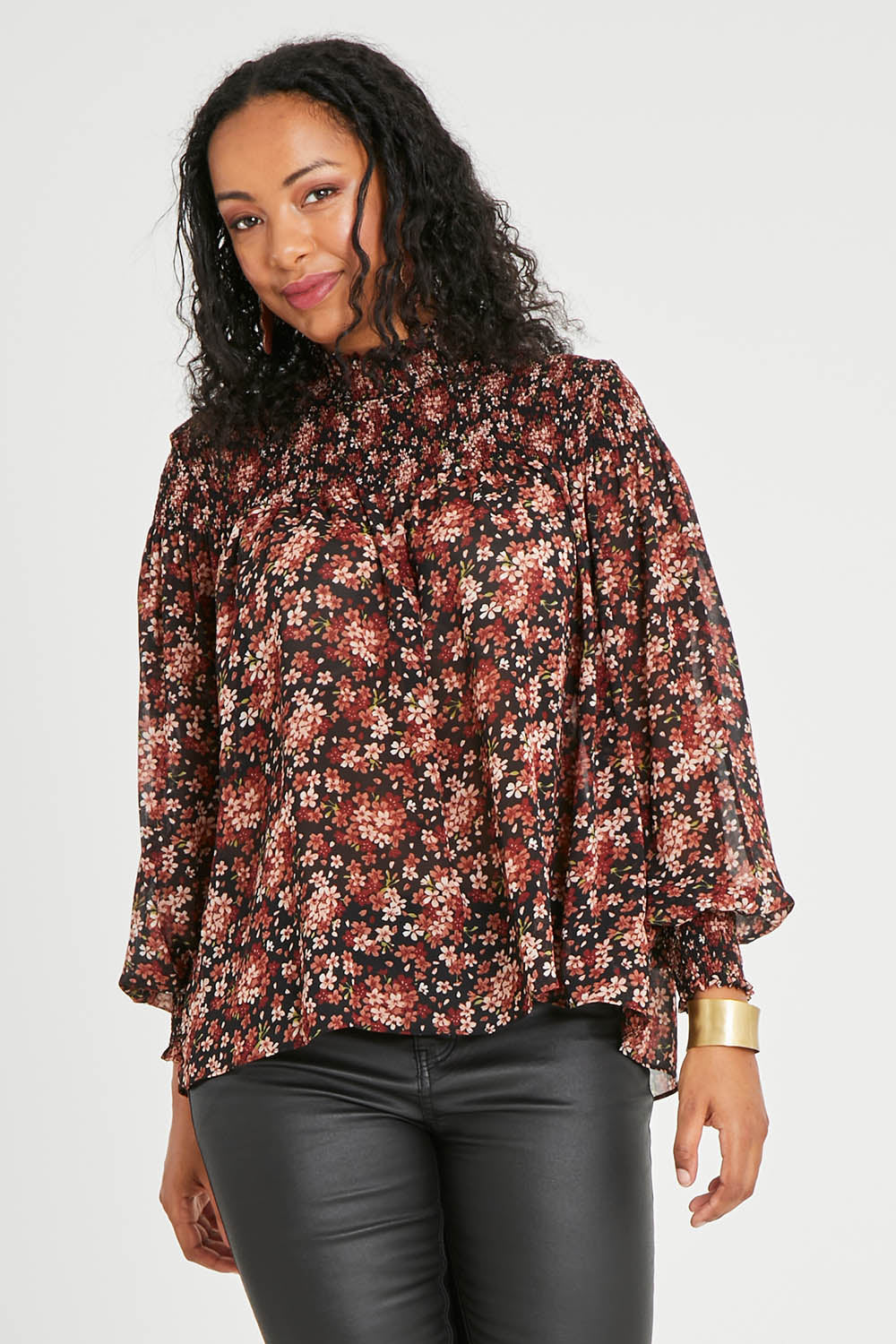 Model Noli wearing size 14 of the Romance In The Air Blouse in colour Blkrust (Black), from the front, cropped image