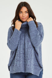 Model Laura wearing size M-L of the Cool Breeze Cable Sweater in colour Denim (Blue), from the front, cropped image