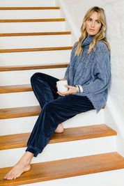 Model Tegan wearing size S-M of the Cool Breeze Cable Sweater in colour Denim (Blue), from the front, showing the whole outfit