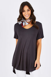 Model Georgia wearing size 10 of the Softly Swinging Bamboo Tee in colour Storm (Grey), from the front, cropped image