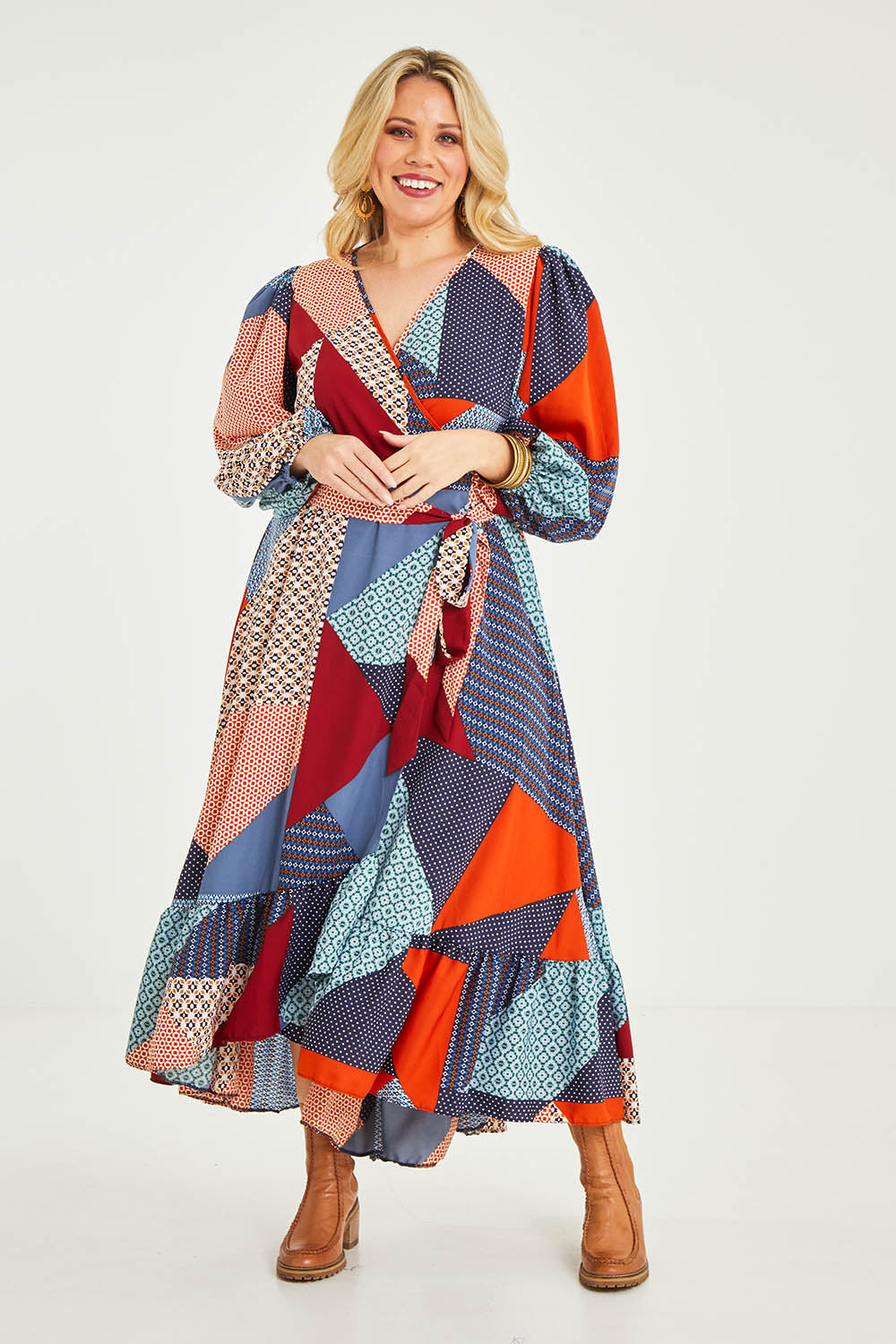 Model Katie wearing size 16 of the La Dolce Vita Print Wrap Dress in colour Geoblue (Blue), from the front, showing the whole outfit