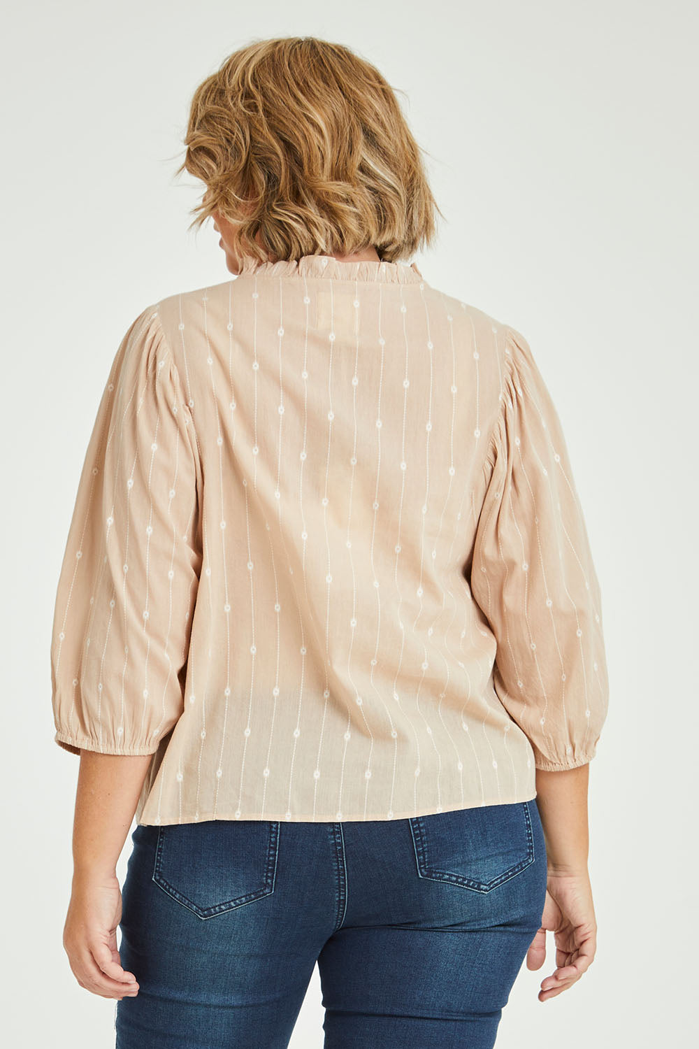 Model Fiona wearing size 16 of the Delighted To Meet You Blouse in colour Sand, from the back