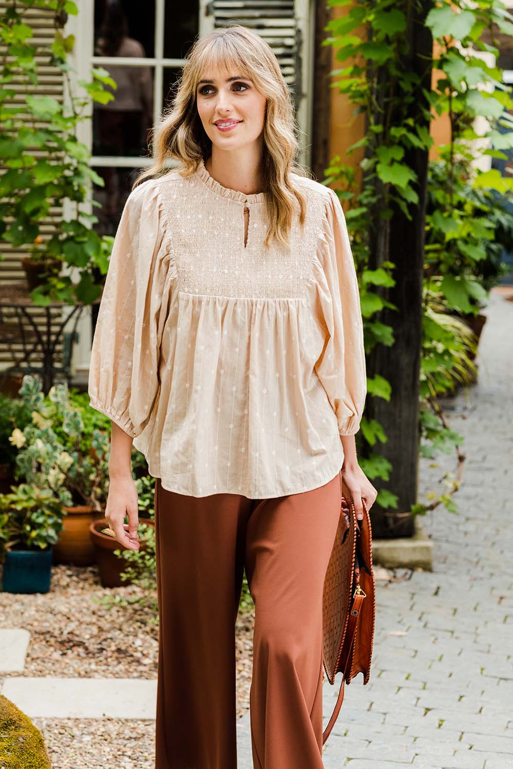 Model Tegan wearing size 10 of the Delighted To Meet You Blouse in colour Sand, from the front, showing the whole outfit