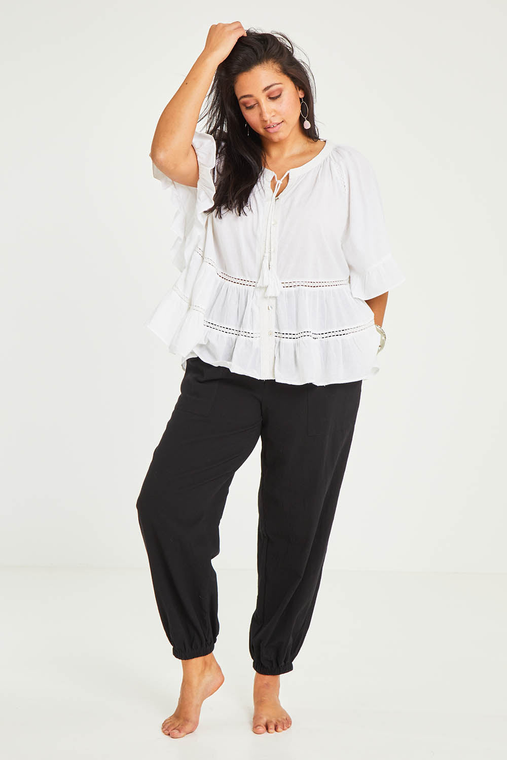 Model Terri-Leigh wearing size 14 of the Dawn Break Relaxed Pants in colour Black (Black), from the front, showing the whole outfit