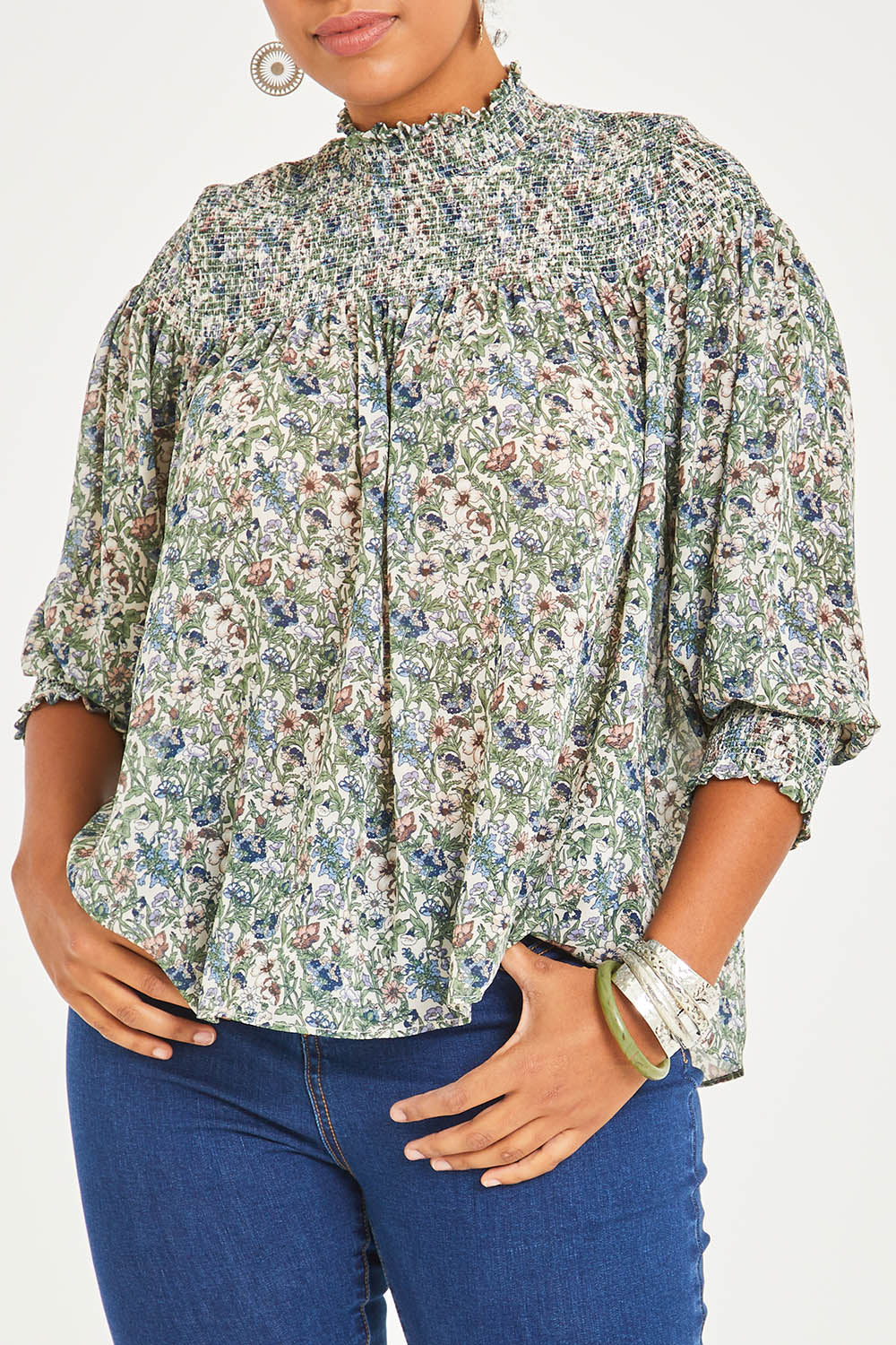 Model Noli wearing size 14 of the Romance In The Air Blouse in colour Fleur (Green), from the front, cropped image