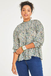 Model Noli wearing size 14 of the Romance In The Air Blouse in colour Fleur (Green), from the front, cropped image