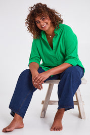 Model Anucia wearing size 14 of the Relaxed Elegance Boyfriend Shirt in colour Emerald (Green), from the front, showing the whole outfit