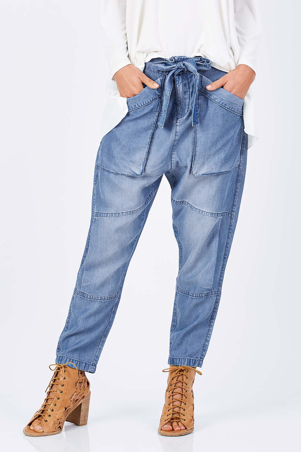 Model Clementine wearing size 10 of the With My Tribe Pants in colour Denim (Blue), from the front, cropped image