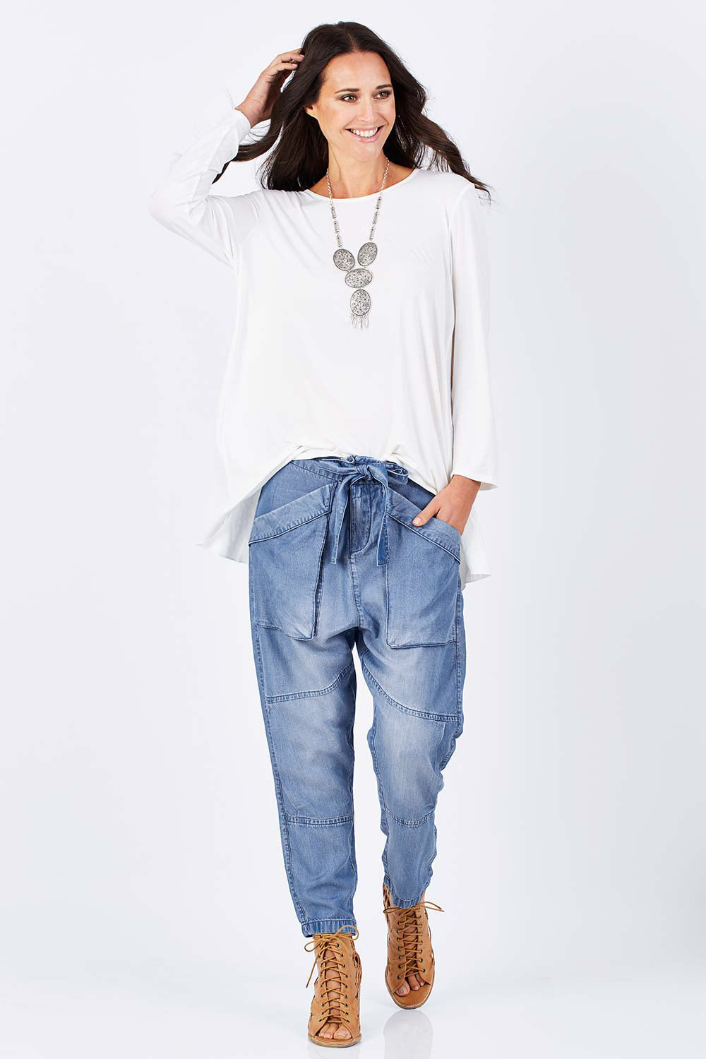 Model Clementine wearing size 10 of the With My Tribe Pants in colour Denim (Blue), from the front, showing the whole outfit