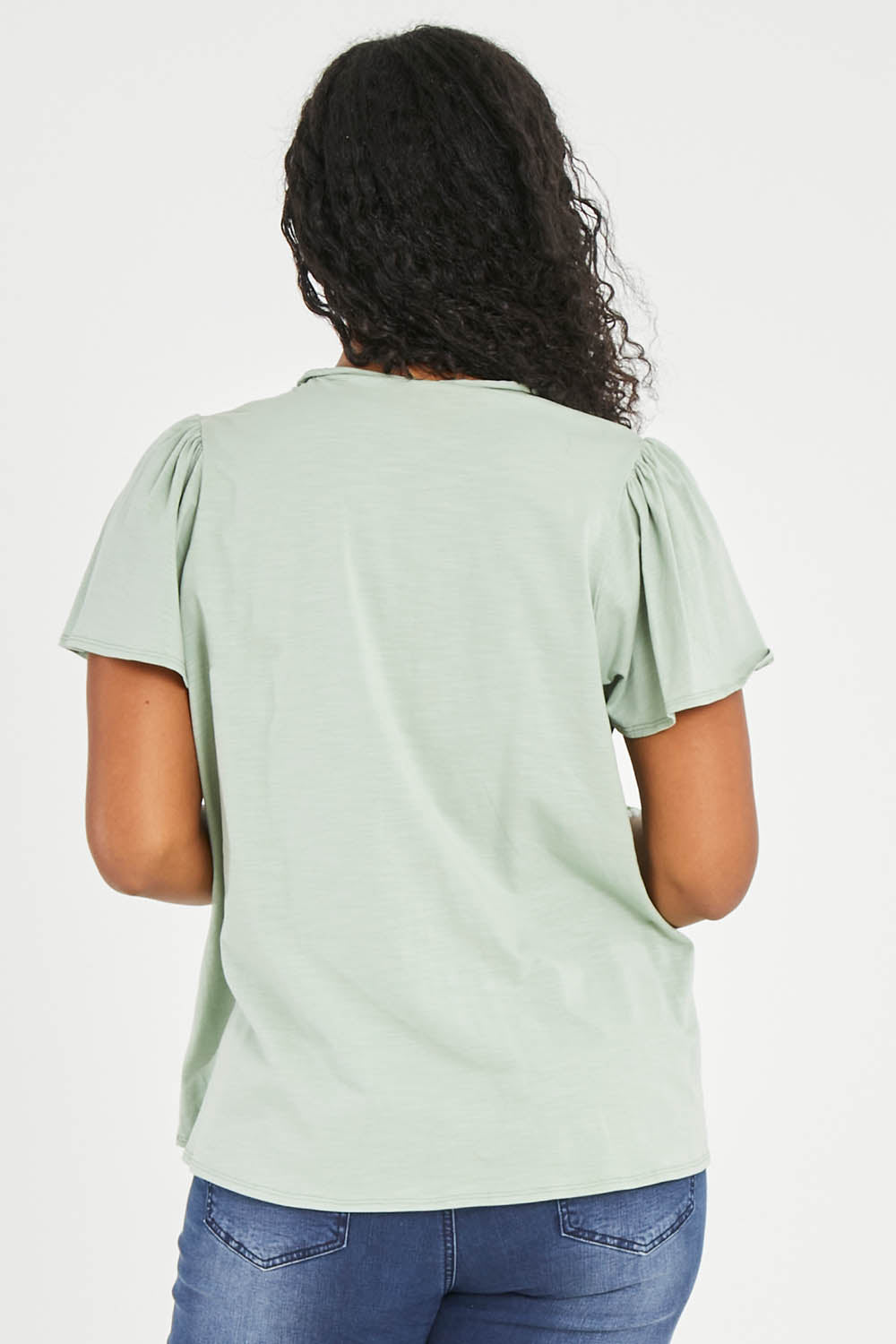 Model Noli wearing size 14 of the Shirred Butterfly Sleeve Tee in colour Sage (Green), from the back