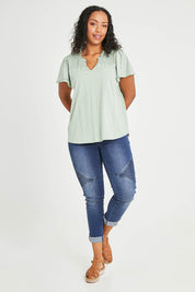 Model Noli wearing size 14 of the Shirred Butterfly Sleeve Tee in colour Sage (Green), from the front, showing the whole outfit
