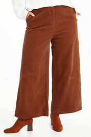 Model Laura wearing size 14 of the Feeling Good Wide Leg Cord Pants in colour Rust, from the front, cropped image