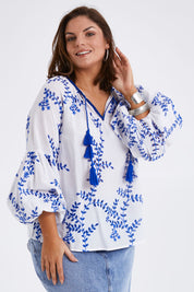 Model Monique wearing size 14 of the Feel My Vibe Embroidered Blouse in colour Whiteblue (White), from the front, cropped image