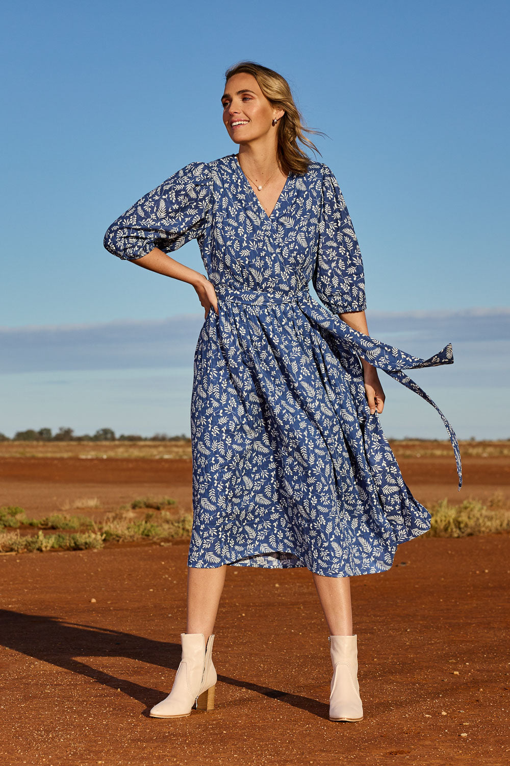 Model Tegan wearing size 10 of the In The Morning Light Wrap Dress in colour Blueleaf (Blue), from the front, showing the whole outfit