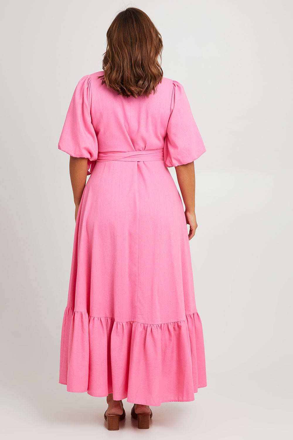 Model Monique wearing size 14 of the La Dolce Vita Puff Sleeve Dress in colour Bubblegum (Pink), from the back