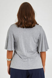 Model Monique wearing size 14 of the Flutter By Tee in colour Lightgrey (Grey), from the back