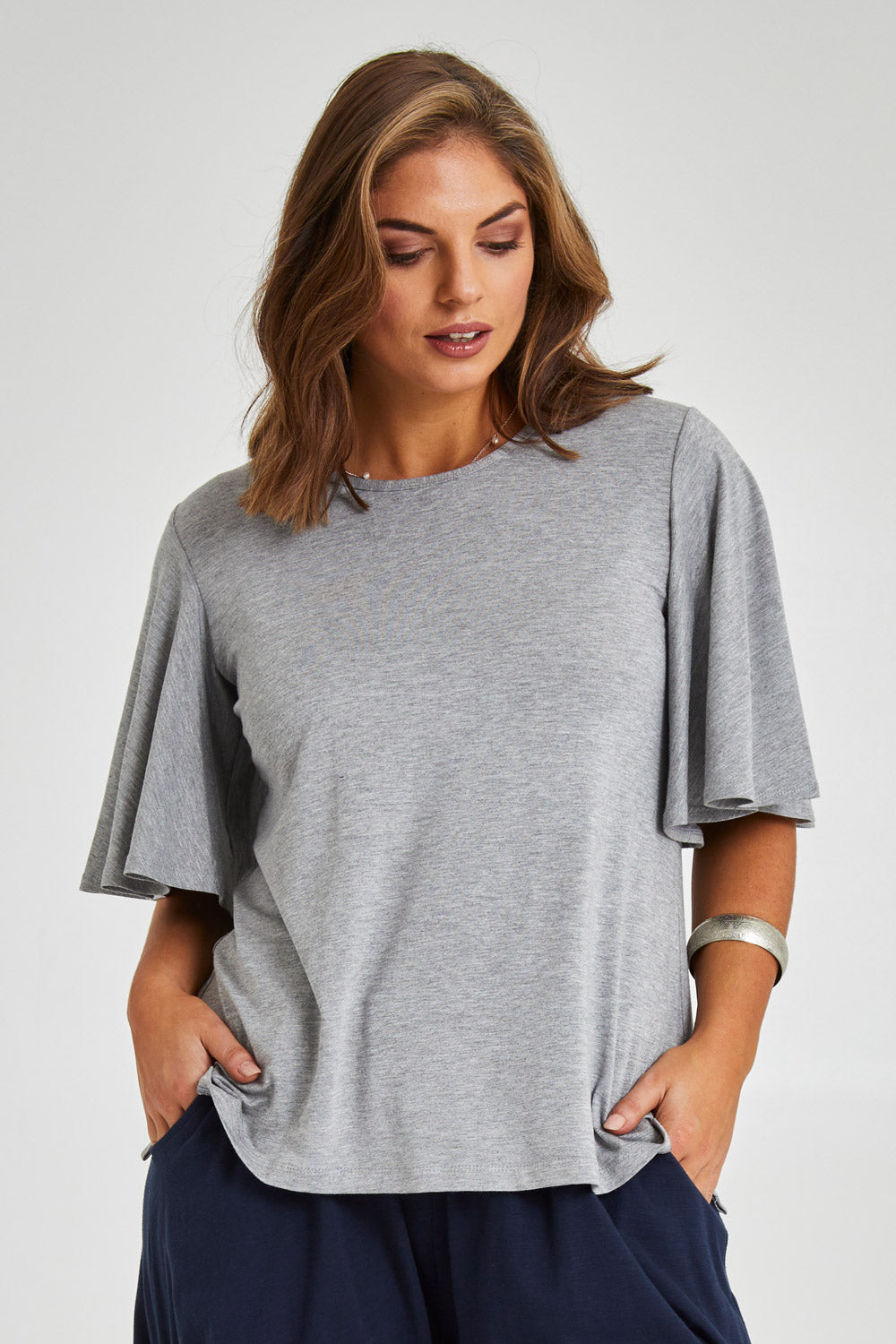 Model Monique wearing size 14 of the Flutter By Tee in colour Lightgrey (Grey), from the front, cropped image