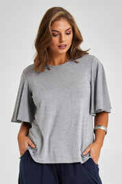 Model Monique wearing size 14 of the Flutter By Tee in colour Lightgrey (Grey), from the front, cropped image