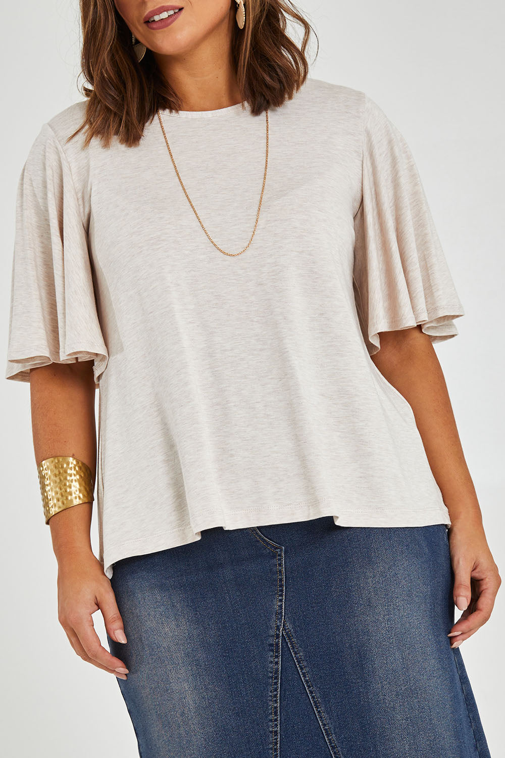 Model Monique wearing size 14 of the Flutter By Tee in colour Natural, from the front, cropped image