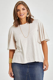 Model Monique wearing size 14 of the Flutter By Tee in colour Natural, from the front, cropped image