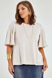 Model Monique wearing size 14 of the Flutter By Tee in colour Natural, from the front, cropped image